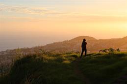 Auf dem Bild sieht man die Silhouette einer Person vor einer Berglandschaft.